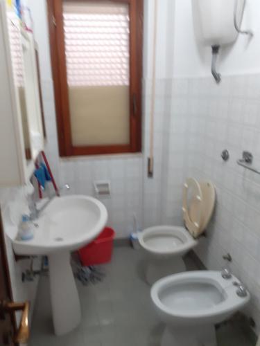 y baño con lavabo, aseo y espejo. en Appartamento Campomarino Lido lungo di mare, en Campomarino