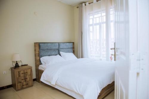 a bedroom with a large bed and a window at Nice Homes Villa in Kigali