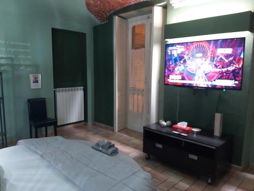 a bedroom with a bed and a television on the wall at I Portici guest house in Alessandria