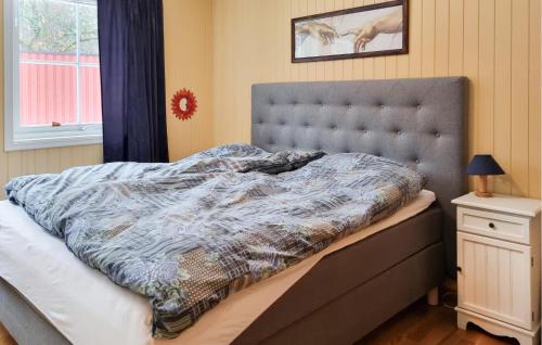 Schlafzimmer mit einem Bett mit blauer Decke in der Unterkunft 4 Bedroom Gorgeous Home In Lyngdal in Lyngdal