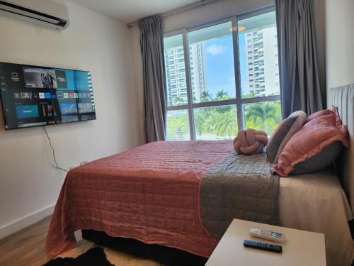1 dormitorio con 1 cama y ventana grande en Loft Ilha Pura en Río de Janeiro
