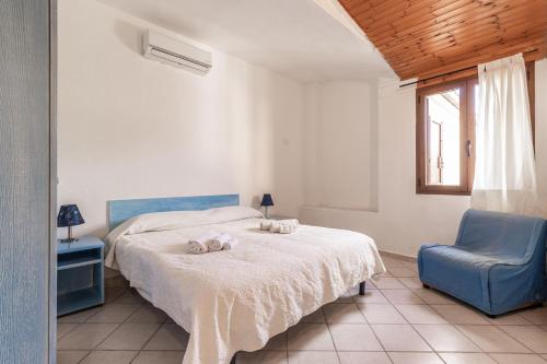 a bedroom with a bed and a blue chair at Baia Turchese Olbia in Olbia