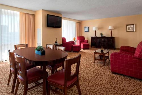 Habitación de hotel con mesa y muebles de color rojo. en Marriott Saddle Brook, en Saddle Brook