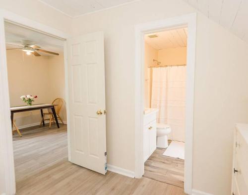 a white bathroom with a toilet and a table at Kinston Hideaway in Kinston