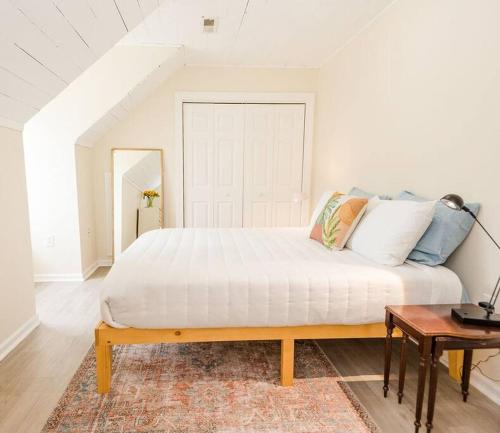 a bedroom with a large white bed and a table at Kinston Hideaway in Kinston