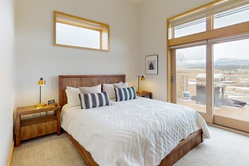 a bedroom with a bed and a large window at Modern Mountain Magic in Eagle
