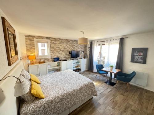 1 dormitorio con cama, mesa y cocina en Studio Centre Plage parking gratuit, en Collioure