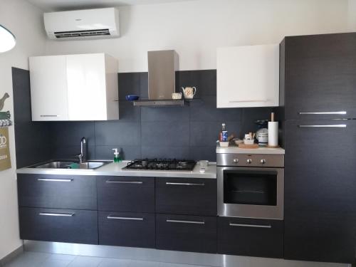a kitchen with stainless steel appliances and white cabinets at APPARTAMENTO LIDA in Lazise