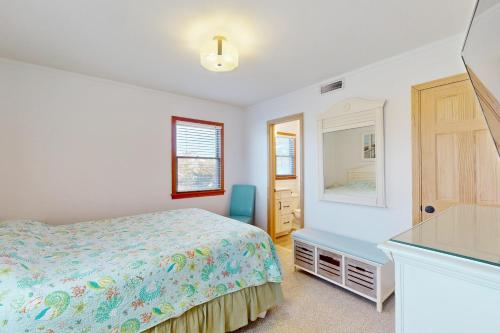 a bedroom with a bed and a dresser and a mirror at AVHC41 Outrigger Cottage on Hatteras Island in Avon