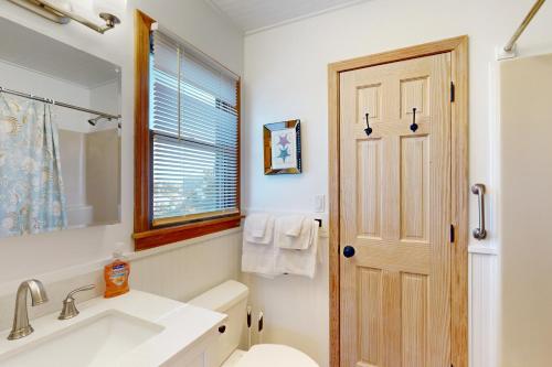 a bathroom with a sink and a toilet and a window at AVHC41 Outrigger Cottage on Hatteras Island in Avon