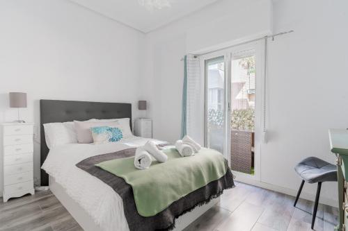um quarto branco com uma cama e uma janela em Enjoy Valencia: Deluxe Apartment with Terrace em Valência