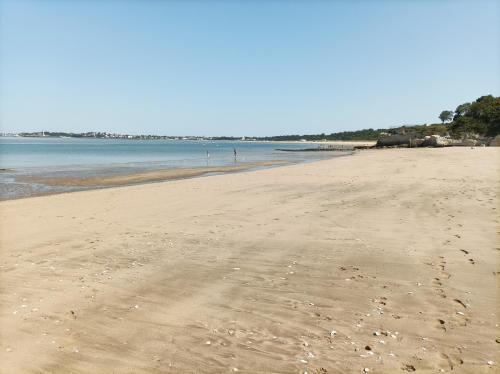 a beach with footprints in the sand and water at Résidence Le Vallon à 180 m de la plage in Saint-Georges-de-Didonne