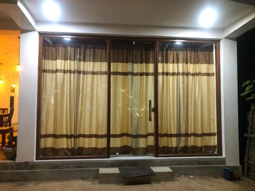a large window with curtains in a room at Oruwa Turtle Beach Villa in Kosgoda
