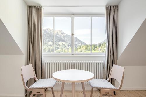 a table and two chairs in front of a window at Lermooser in Lermoos