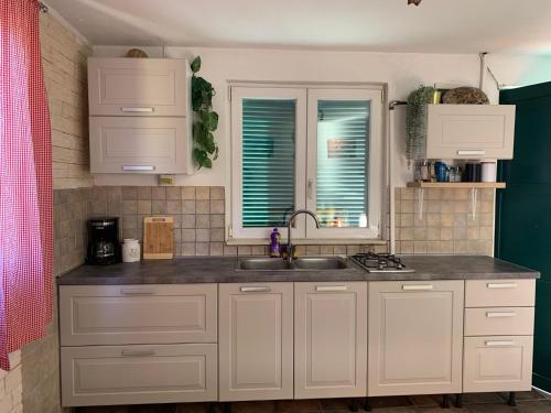 a kitchen with white cabinets and a sink at House Lovre in Tkon