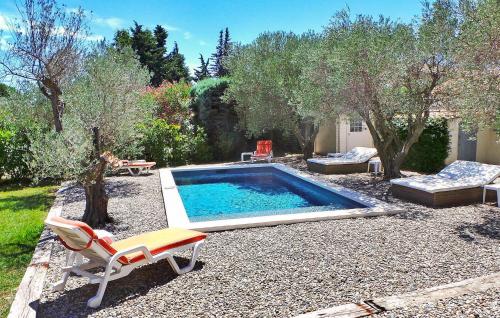a swimming pool in a yard with a chair and a table at Le Roman Bleu in Paradou