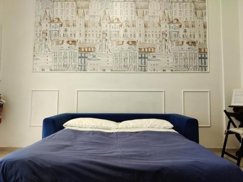 Un dormitorio con una cama azul con una foto en la pared en Bologna Travel Suite en Bolonia