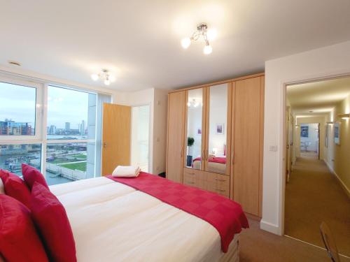 a bedroom with a large bed and a large window at London ExCeL Stays - Three Bed Serviced Apartment in London