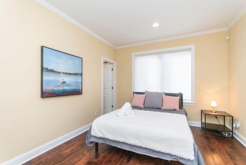 a bedroom with a bed and a large window at Huge 4 Bdrm - Roof Deck - Parking - Soak Tub! in Philadelphia