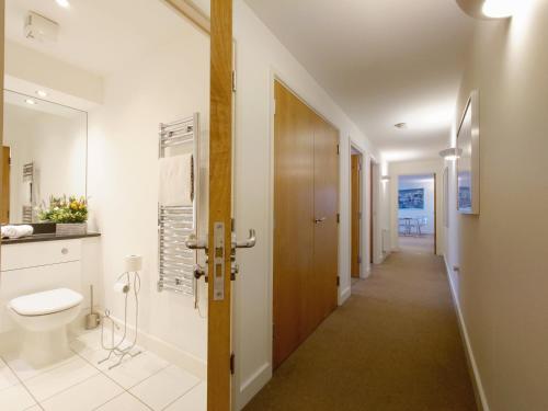London ExCeL Stays - Three Bed Serviced Apartment في لندن: حمام مع مرحاض وممر