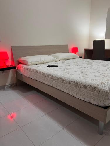 Bett in einem Zimmer mit roter Beleuchtung in der Unterkunft B&B il Tulipano in Muro Lucano