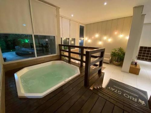 a jacuzzi tub in a room with a large window at Rio Stay suite Rio Centro in Rio de Janeiro