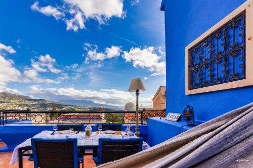 un restaurante con una pared azul, mesas y sillas en Ryad A&B Chaouen, en Chefchaouen