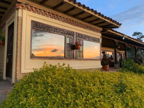 a house with a window with a sunset in it at Casas La Primavera in Villa de Leyva