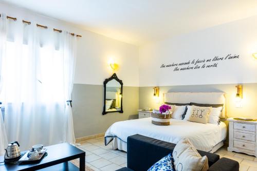a bedroom with a bed and a couch at Le Maschere B&B in Santa Teresa Gallura