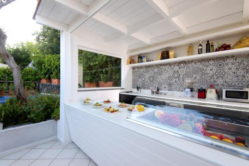 a kitchen with a counter with food in a window at Hotel Villa Durrueli Resort & Spa in Ischia