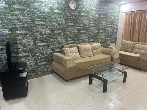 a living room with two couches and a tv at Mangala stay home (Malleshwaram) Ground Floor Apts in Bangalore