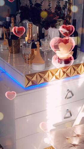 a dresser with wine glasses and wine bottles on it at PARADIS CHAMBRES D'HÔTES PROCHE PARIS - AÉROPORT CHARLES DE GAULLE AIRPORT - PARC DES EXPOSITION VILLEPINTE - DYSNAYLAND PARIS. in Tremblay En France