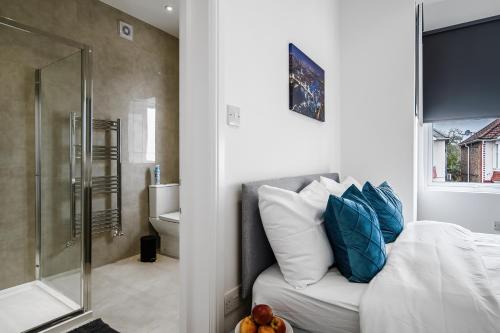 a bedroom with a bed and a glass shower at Modern Studio Rooms in Wembley in London