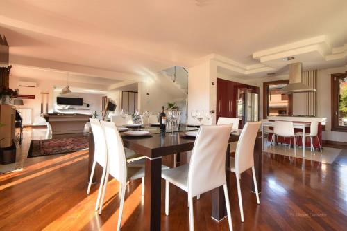 una sala da pranzo e una cucina con tavolo e sedie di Welc-oM Villa Noventa Padovana a Noventa