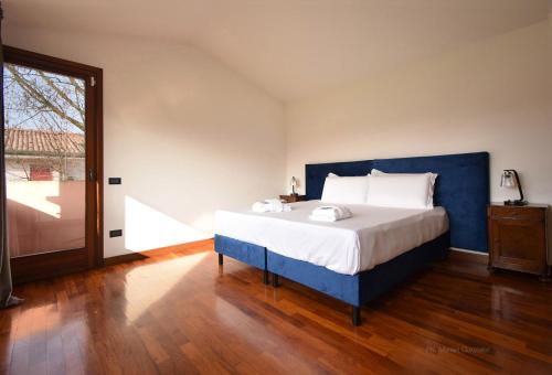 una camera con un grande letto con testiera blu di Welc-oM Villa Noventa Padovana a Noventa