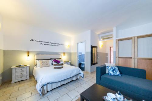 a hotel room with a bed and a couch at Le Maschere B&B in Santa Teresa Gallura
