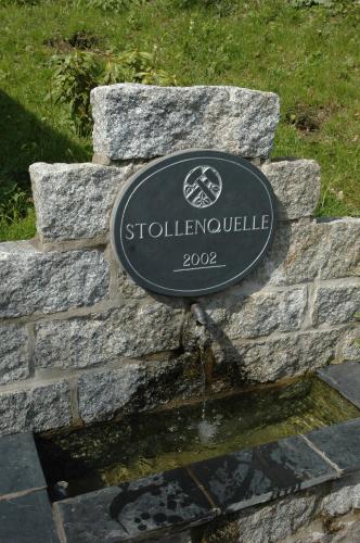 a sign on top of a stone wall at Flair-Waldhotel Mellestollen in Saalfeld