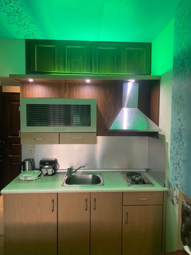 a kitchen with a sink and a stove with green lighting at Captain's Beach Apartments in Limenas