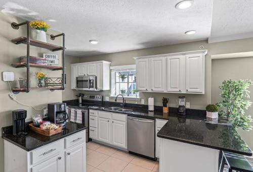 a kitchen with white cabinets and black counter tops at 2BR Condo - Near SDC - 2 Pools - Golf Onsite - FREE TICKETS INCLUDED - SB 9-5 in Branson