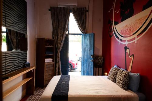 a bedroom with a bed and a large window at Chuchumbé Hotel & Hostal in Veracruz