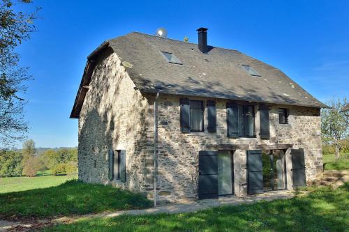 an old stone house on a grassy field at Domaine de la Clauzade in Saint-Germain-les-Vergnes
