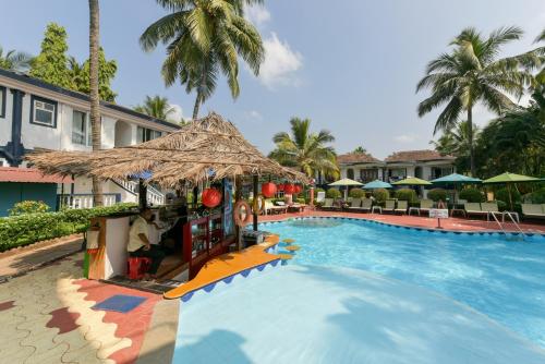 una piscina resort con un paseo en el centro en 2 Bedroom Apartment in Resort on Candolim Beach, en Baga
