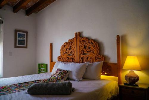 a bed with a wooden headboard in a bedroom at Casa Margarita , La fuente de la luna in Tequisquiapan