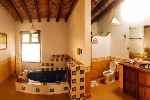 a large bathroom with a tub and a toilet at Casa Margarita , La fuente de la luna in Tequisquiapan