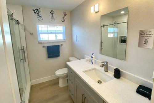 ein Badezimmer mit einem Waschbecken, einem WC und einem Spiegel in der Unterkunft Waterfront Gulf Gateway: Pool/Dock/Grill/Gameroom in Fort Myers