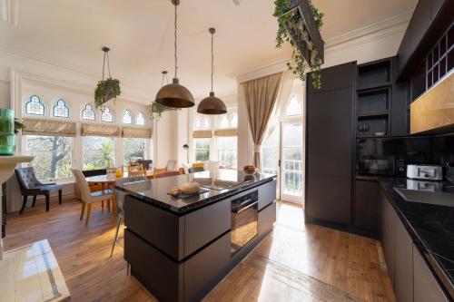 a kitchen with black cabinets and a dining room at Westwell Hall in Ilfracombe