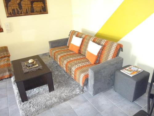 a living room with a couch and a table at Maison Ambre Guesthouse in Windhoek