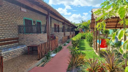 einen Innenhof eines Hauses mit Pflanzen und einem Zaun in der Unterkunft Pousada Brasil in São Miguel do Gostoso