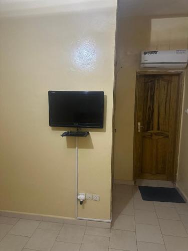 a flat screen tv on a wall next to a door at THURIN IMO in Saint-Louis