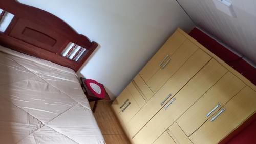 - une chambre avec un lit, 2 tiroirs et une sidx dans l'établissement Casa boa vista, à Campos do Jordão